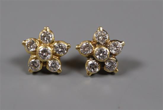 A pair of yellow metal and diamond set flower head earstuds, (one back missing).